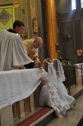 Father Wojdelski FSSP Administers First Holy Communion to Two Young Ladies of the Parish