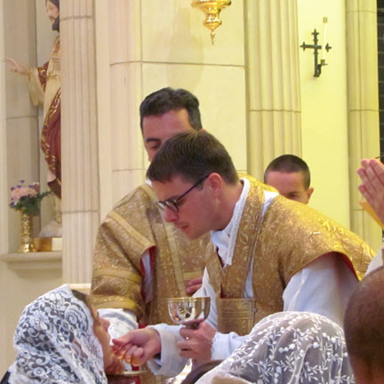 Fr. Karl Marsolle administering Holy Communion