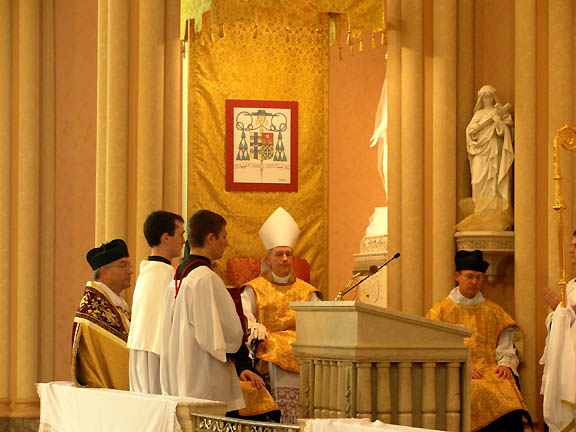 At the throne: Bishop Paprocki seated with Fr. Daren Zehnle at his right and Fr. Devillers at his left with Fr. Bisig seated to the Bishop's right behind the altar servers.